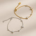 Two gold and silver bracelets with star-shaped stones on a beige background