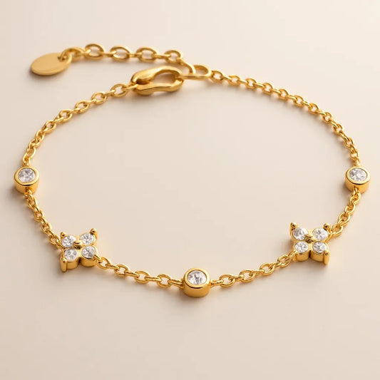 Gold bracelet with diamond-like stones on a beige background