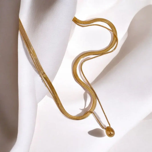 Gold necklace with a pendant on a white background