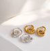 Pair of silver and gold hoop earrings on a light surface