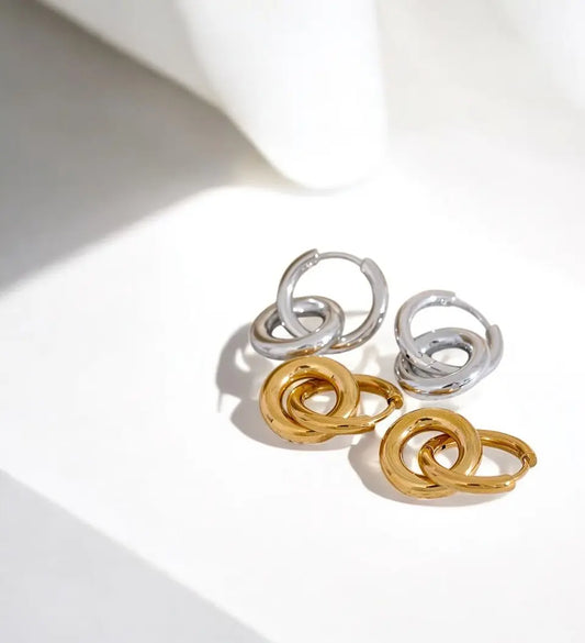 Pair of gold and silver hoop earrings on a light background