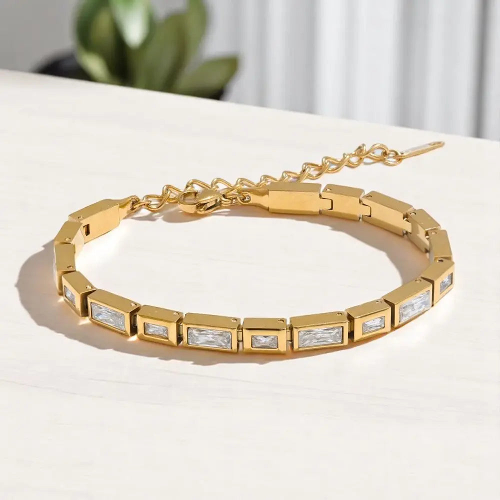 Gold bracelet with embedded crystals on a light surface