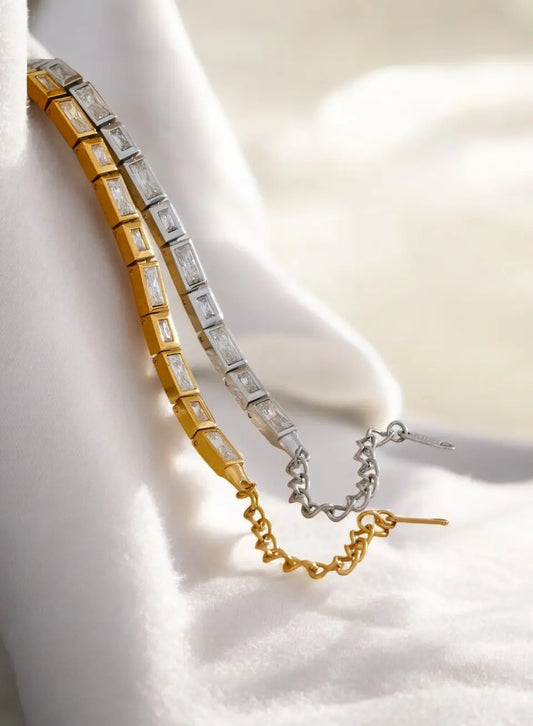 Gold and silver bracelet on a white fabric background