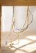 Close-up of a necklace with a pendant on a wooden surface