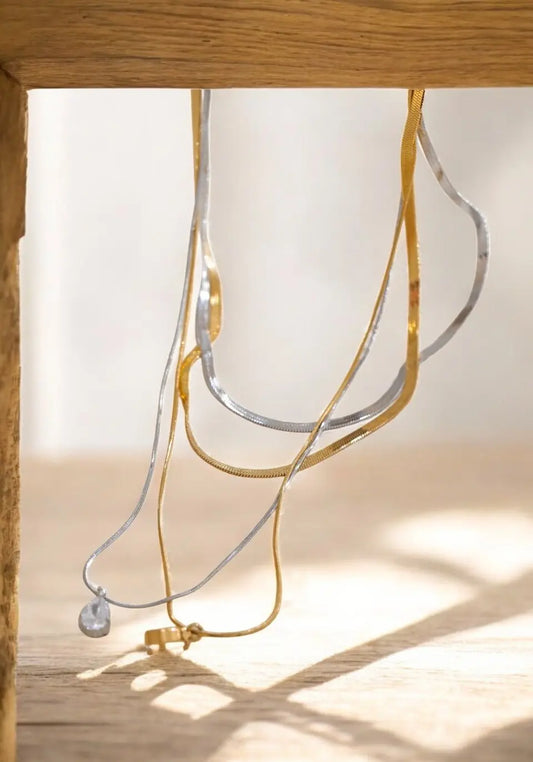 Close-up of a necklace with a pendant on a wooden surface