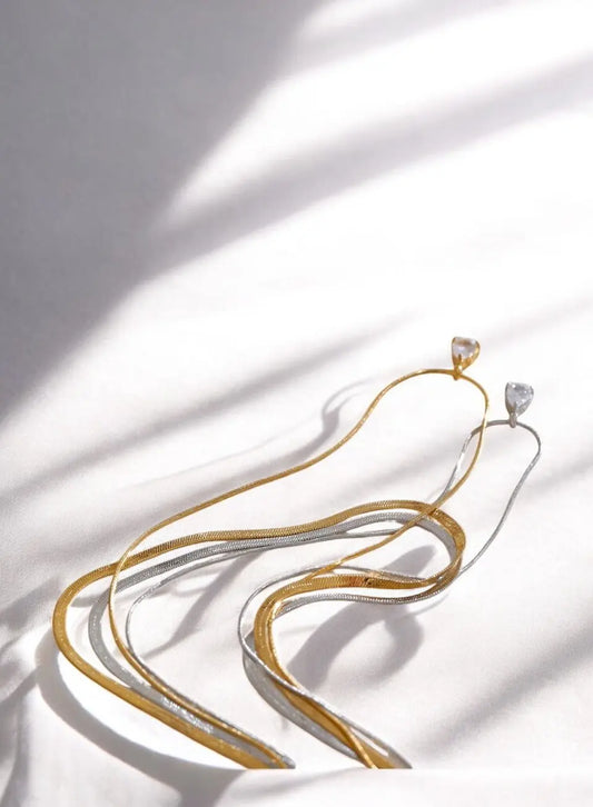 Gold necklace with a diamond pendant on a white fabric background