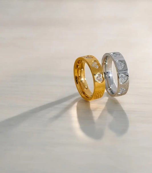 Two wedding rings, one gold and one silver, on a light background