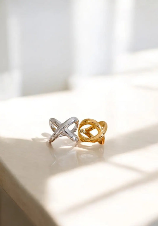 Two rings, one gold and one silver, on a light surface with a soft background.