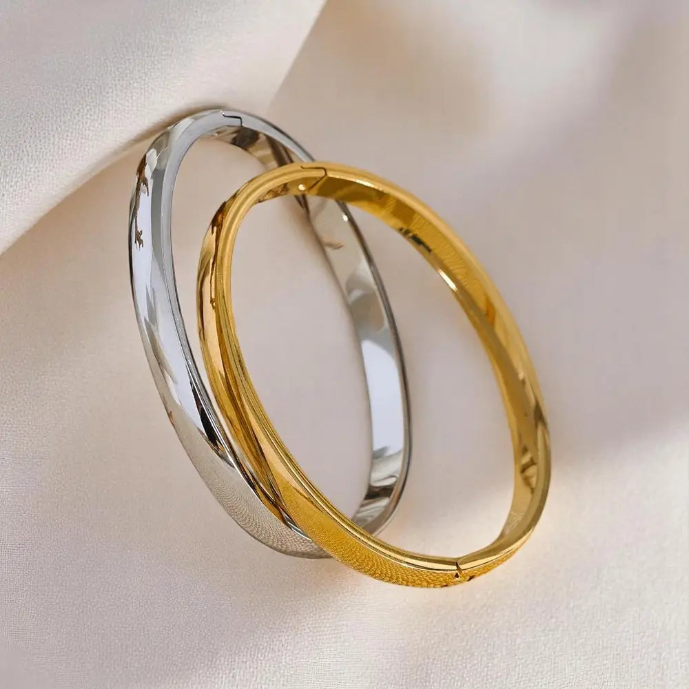 Gold and silver hoop earrings on a light fabric background