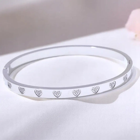 Silver bracelet with heart-shaped cutout design on a white surface