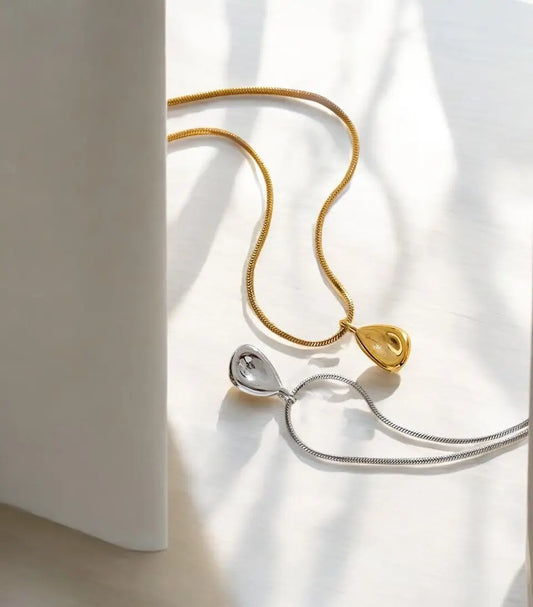 Gold and silver necklaces on a light fabric background