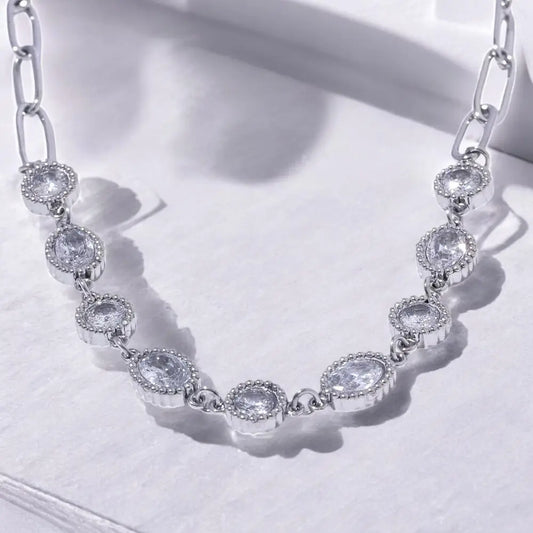 Silver necklace with clear gemstones on a white background
