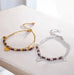 Two beaded bracelets, one gold and one silver, on a light surface.