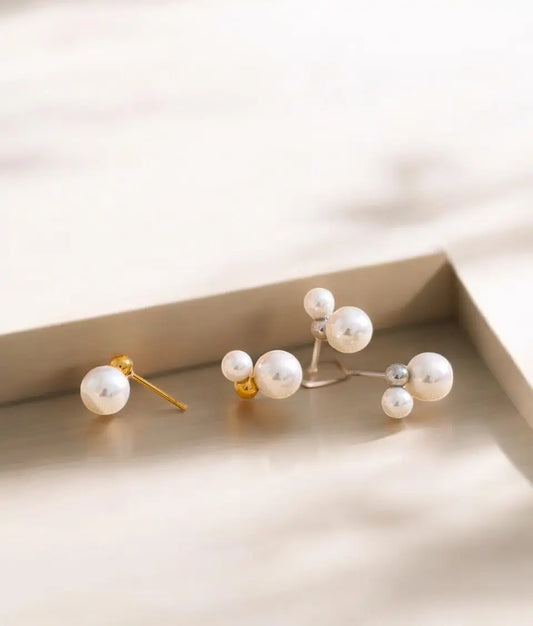 Pair of pearl earrings on a light surface with a soft background