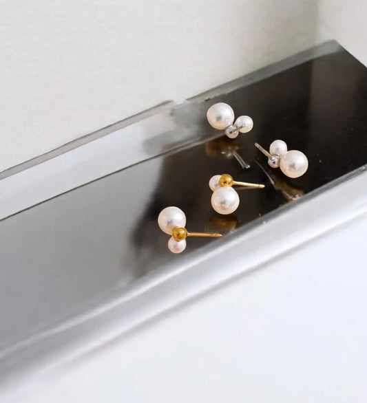 Pearl earrings on a black and white surface