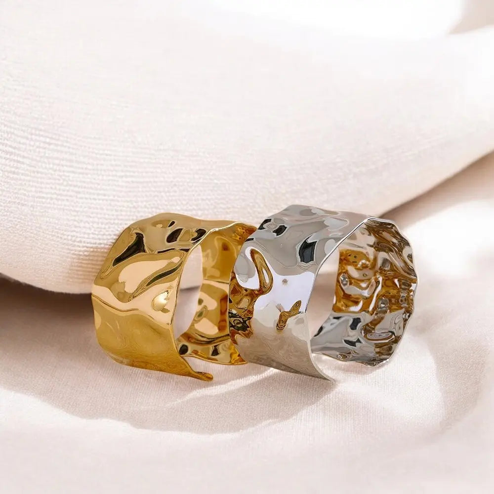 Two gold and silver rings on a white fabric background