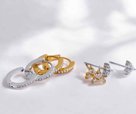 Pair of gold and silver earrings on a light gray background