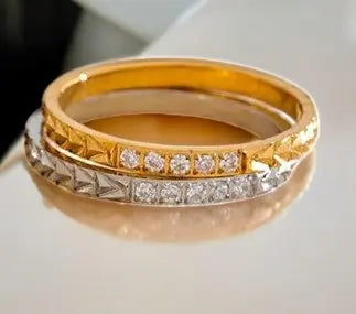 Two gold rings with diamond accents on a light background