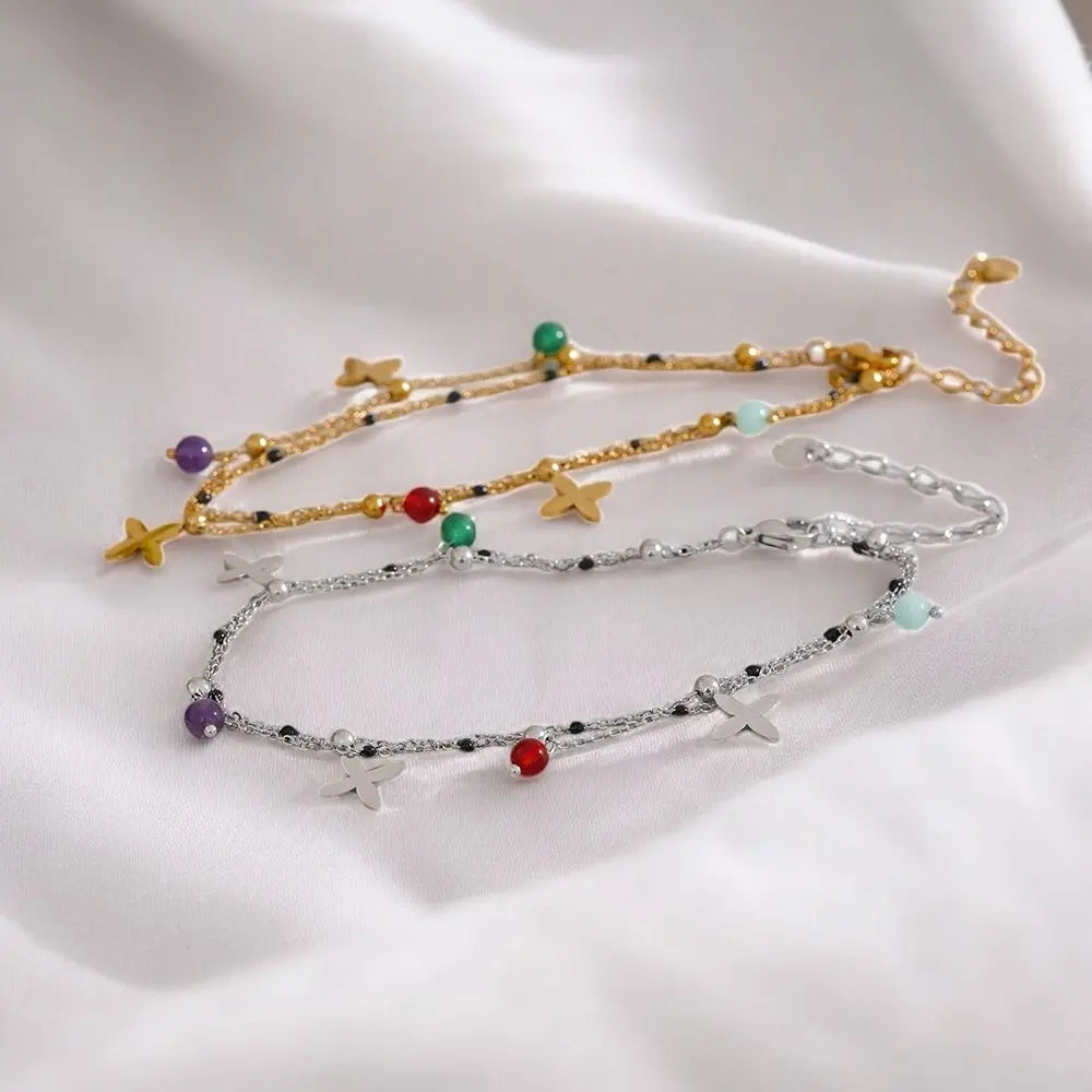 Two bracelets with star and bead details on a white surface