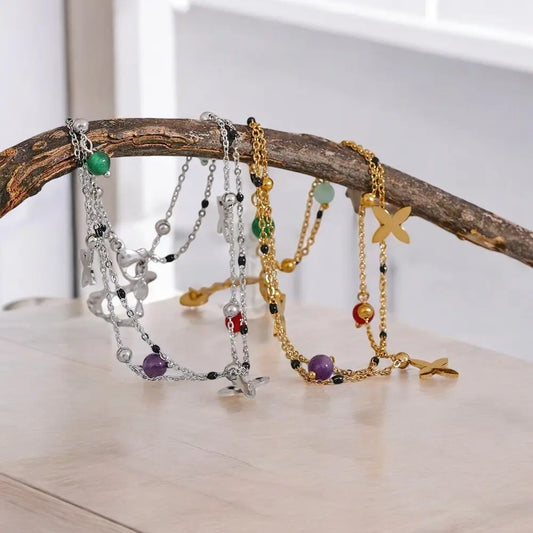 Three bracelets on a branch with a neutral background