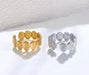 Gold and silver shell-patterned rings on a white background