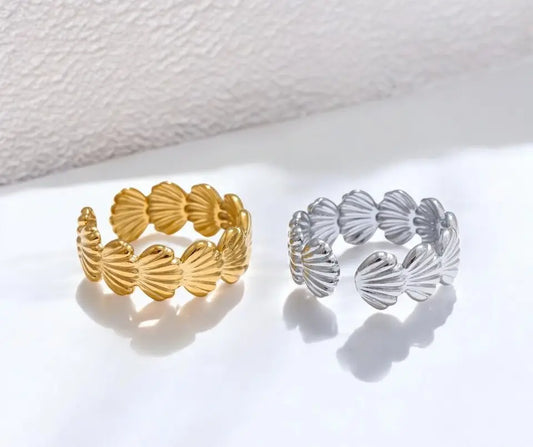 Gold and silver shell-patterned rings on a white background