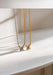 Two butterfly-shaped pendants on gold and silver chains against a white background