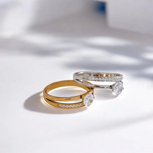 Two diamond-studded rings on a light surface with soft shadows