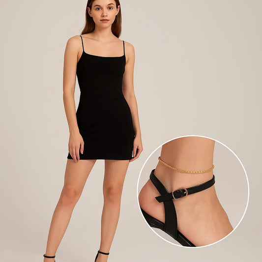 Woman wearing a black slip dress with a close-up of a gold anklet on a beige background