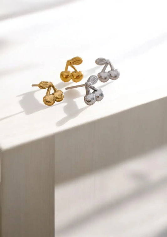 Pair of gold and silver earrings on a light surface