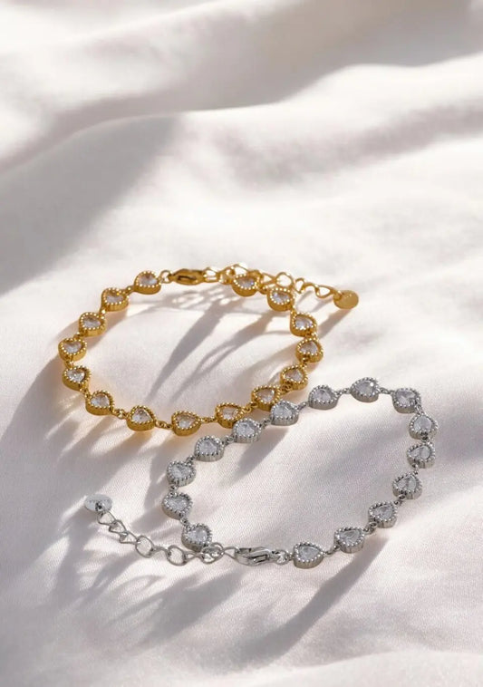 Two gold and silver bracelet sets on a white fabric background