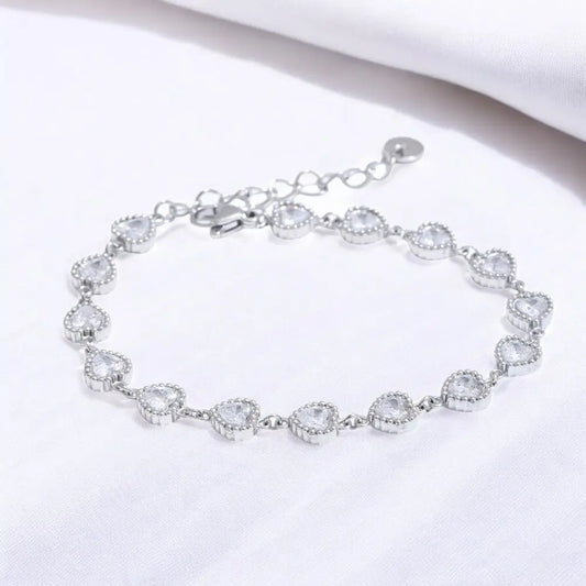 Silver bracelet with clear gemstones on a white background