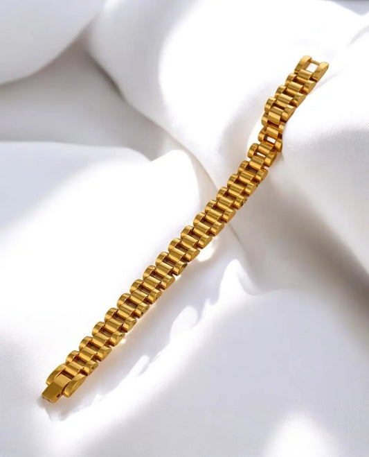 Gold bracelet on a white fabric background