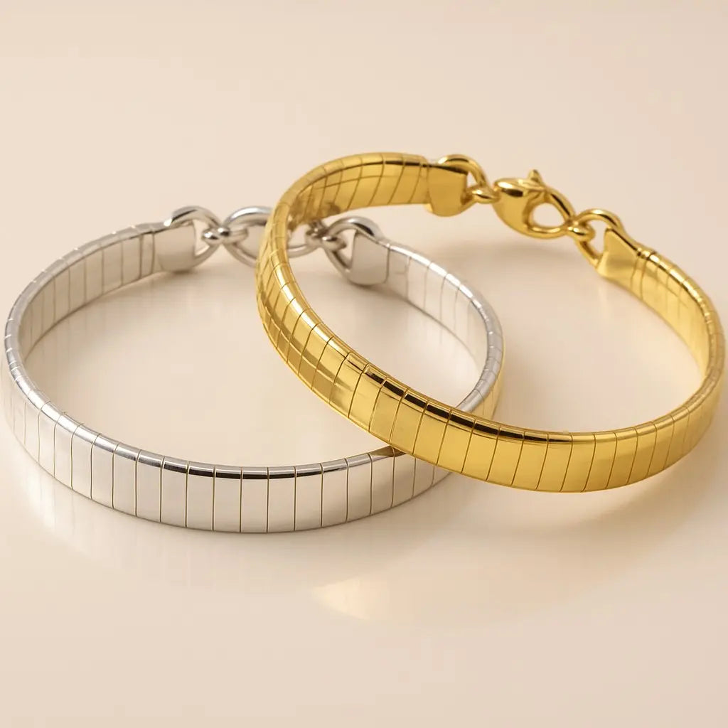 Two bracelets, one gold and one silver, on a beige background