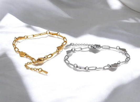 Gold and silver chain bracelets on a light background
