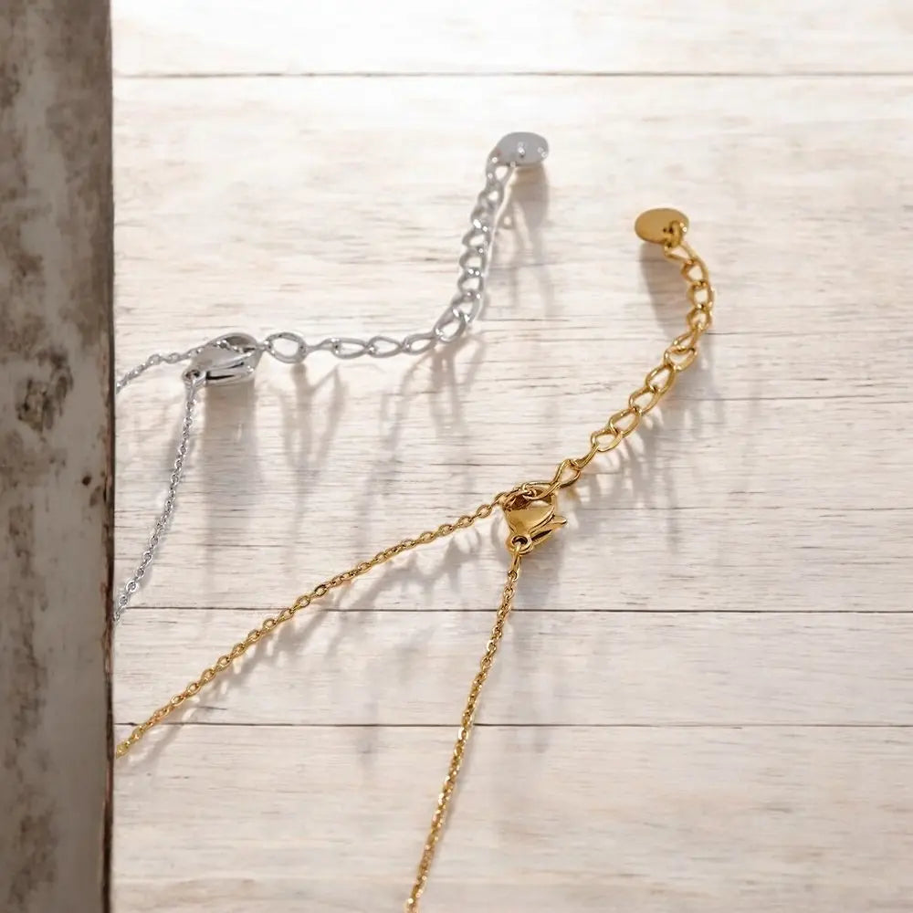 Gold and silver chain necklaces on a wooden surface