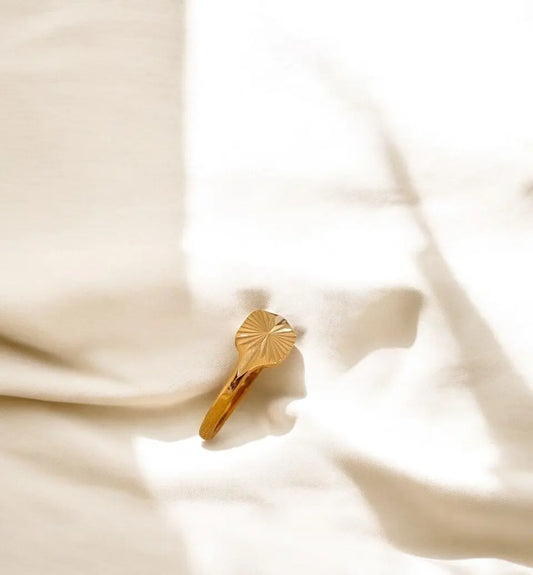 Gold hair clip on a soft beige fabric background