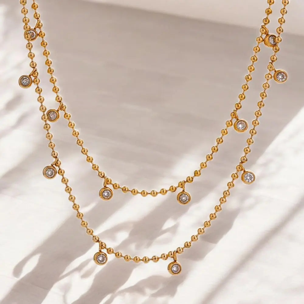Gold necklace with small diamonds on a beige background
