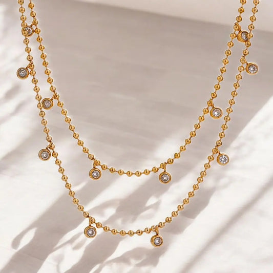 Gold necklace with small diamonds on a beige background