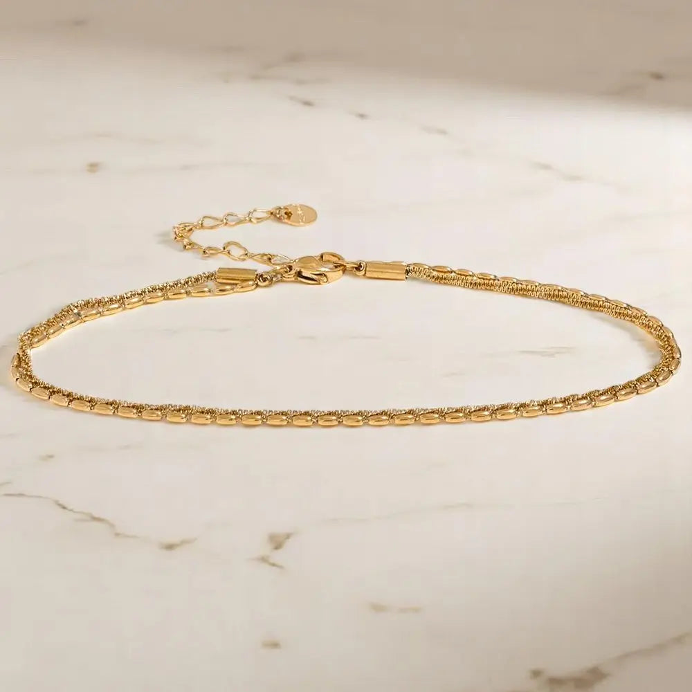 Gold bracelet on a marble surface