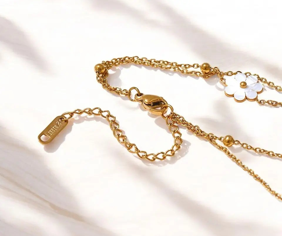 Gold chain necklace with a clasp on a light fabric background