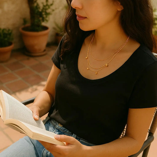 Woman reading a book outdoors with plants in the background