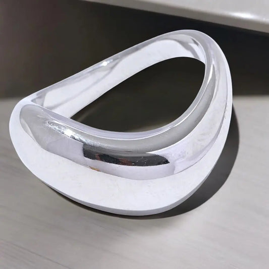 Silver and white dental guard on a reflective surface