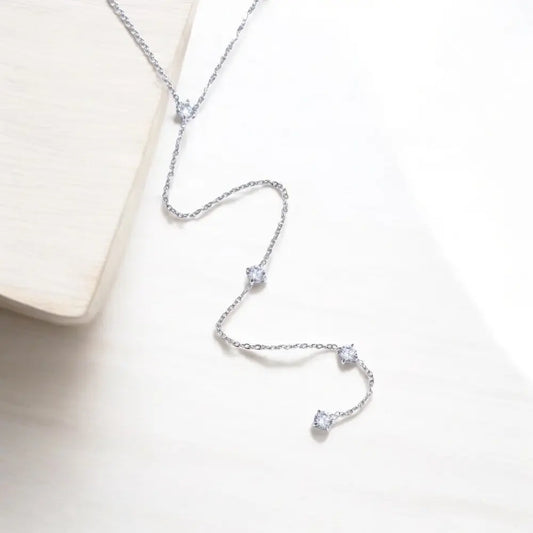 Silver necklace with small diamonds on a light background