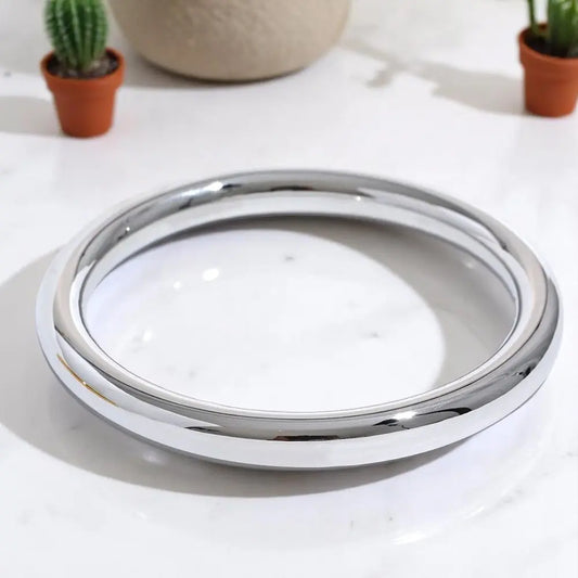 Chrome rim on a white surface with potted plants in the background
