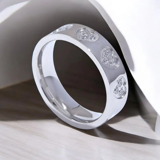 Silver ring with heart-shaped gemstones on a light background