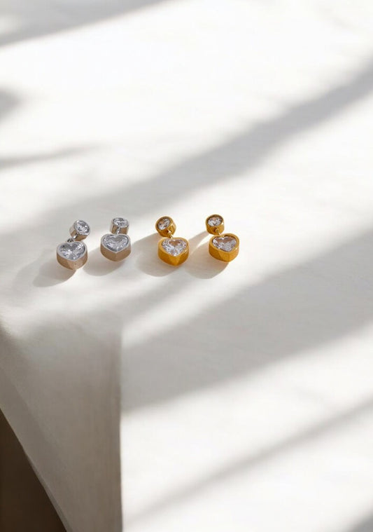Set of three earrings on a white surface with soft shadows