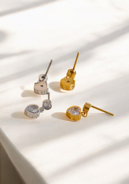 Gold and silver earrings on a light background