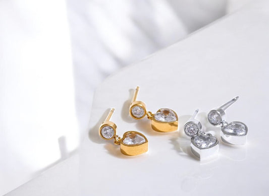 Gold and silver earrings on a white surface