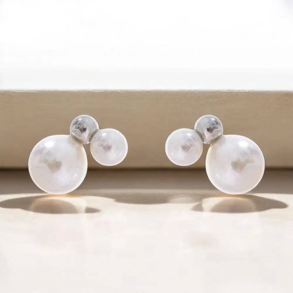 Pair of pearl earrings on a neutral background